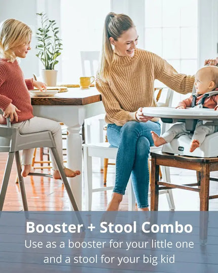 Two women with a child using a booster and stool combo at a dining table.