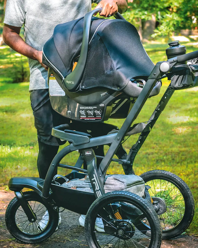 Stroller with a car seat attachment in a park setting