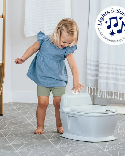 Child interacting with a children's toilet trainer in a bathroom setting.