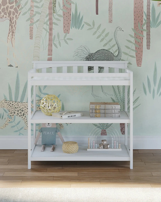 White changing table with decorative items against a wall with animal prints