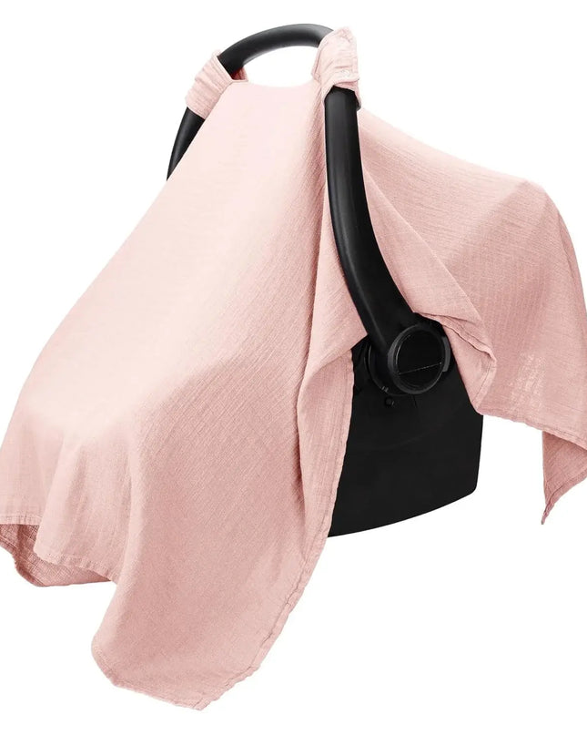 Pink baby car seat cover draped over a black baby carrier on a white background