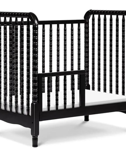 Black crib with white mattress on a white background