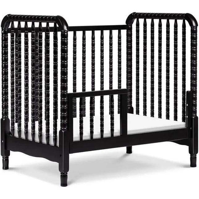 Black crib with white mattress on a white background