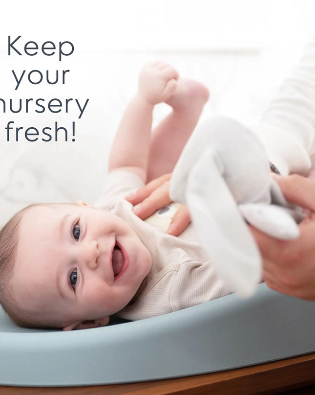 Baby lying on a changing table with text 'Keep your nursery fresh!'