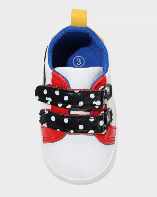 Children's shoe with polka dot straps on a white background