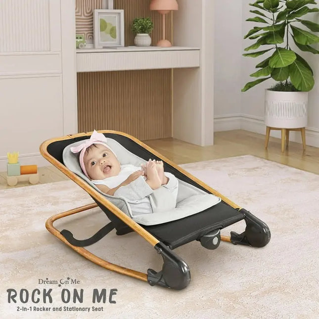Baby in a rocker seat in a room with a desk and plant
