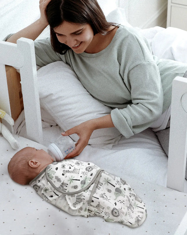 Woman feeding a baby with a bottle in a crib