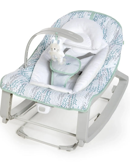 Baby rocker with green and white patterned cover on a white background
