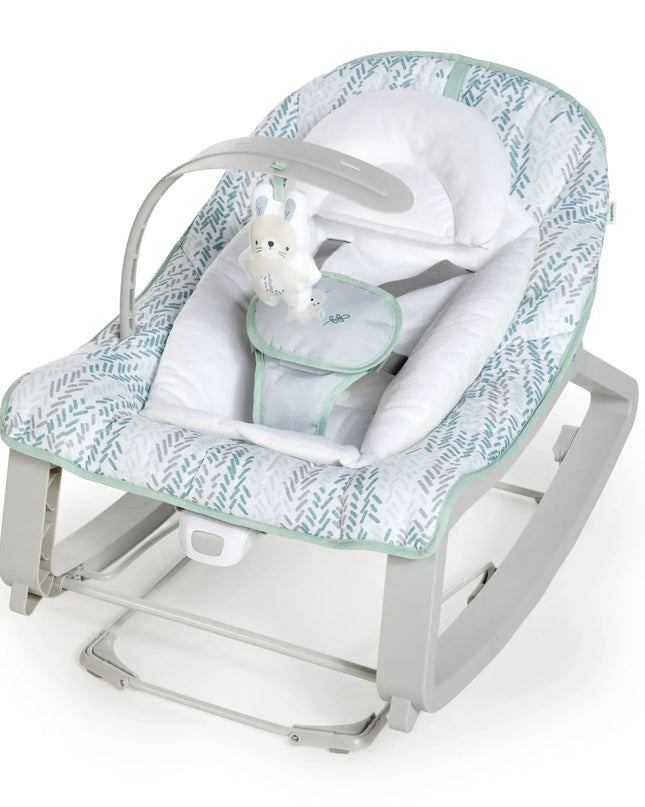 Baby rocker with green and white patterned cover on a white background