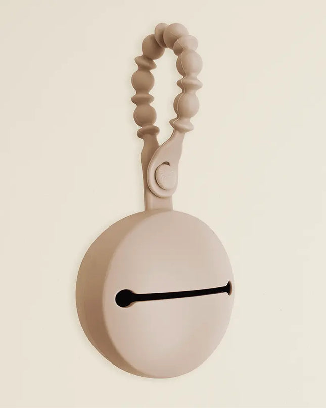 Beige wall clock with decorative handle on a beige background