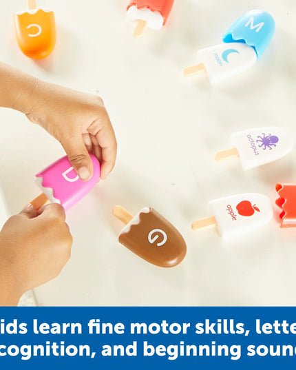 Children's hands interacting with colorful ice cream-shaped letters on a white surface.