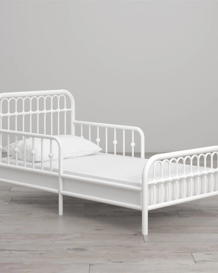 White metal children's bed with a gray background