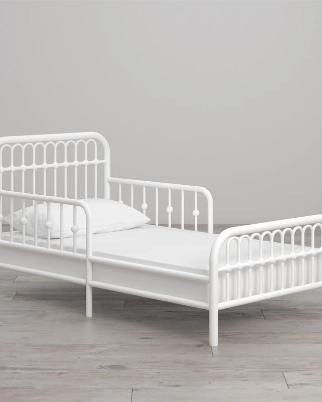 White metal children's bed with a gray background