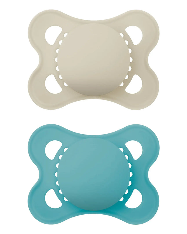Two baby pacifiers, one beige and one blue, on a white background