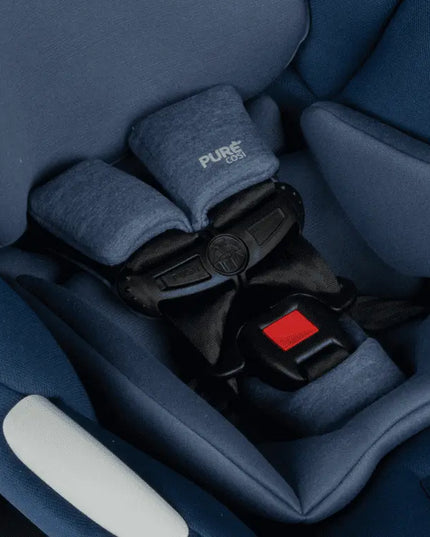 Close-up of a blue car seat with a visible brand logo, showing the harness system.