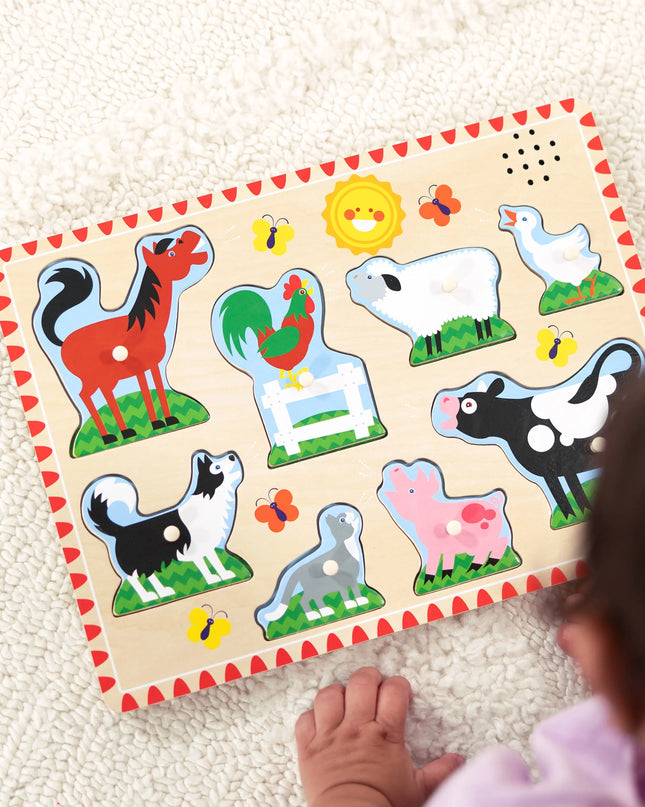 Child playing with a wooden farm animal puzzle on a light-colored surface
