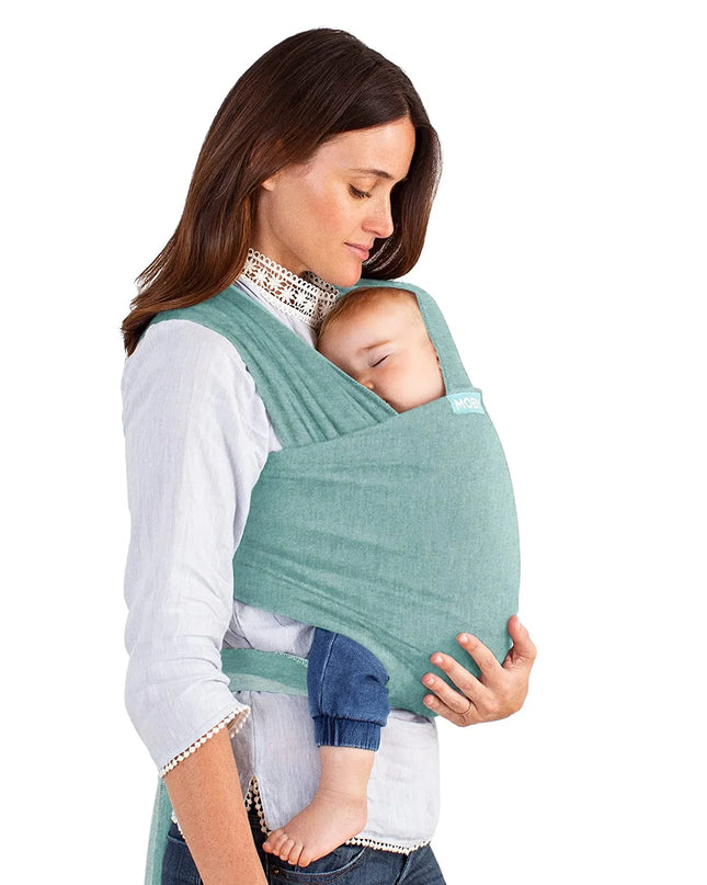 Woman breastfeeding a baby using a green sling against a white background