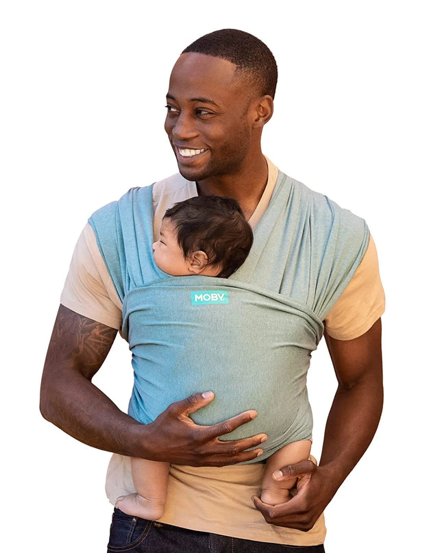 Man holding a baby in a blue and gray baby carrier on a white background