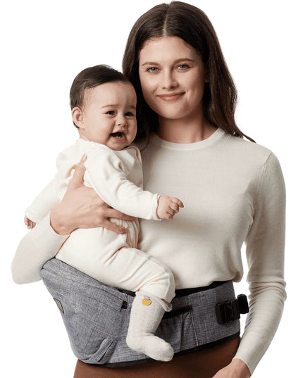 Woman holding a baby in a gray baby carrier against a white background