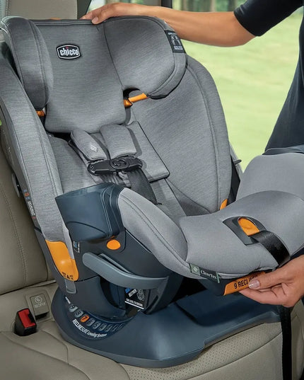 Gray and blue car seat with orange accents being adjusted inside a vehicle.