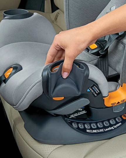 Person adjusting a gray car seat with orange accents in a vehicle.