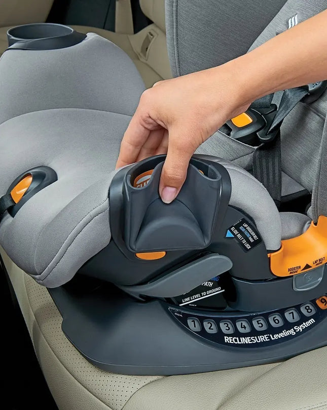 Person adjusting a gray car seat with orange accents in a vehicle.
