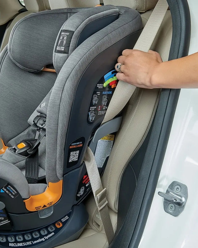 Person securing a gray car seat in a vehicle