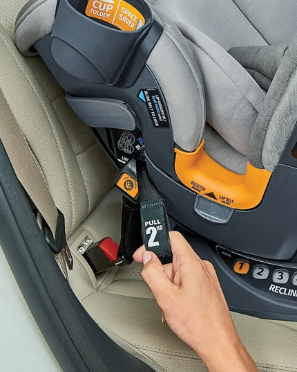 Hand adjusting a car seat belt on a child car seat in a vehicle.