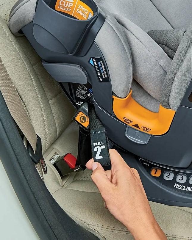 Hand adjusting a car seat belt on a child car seat in a vehicle.