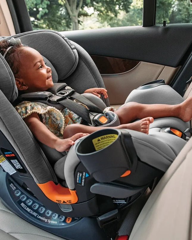 Child in a car seat inside a vehicle with a blurred outdoor background