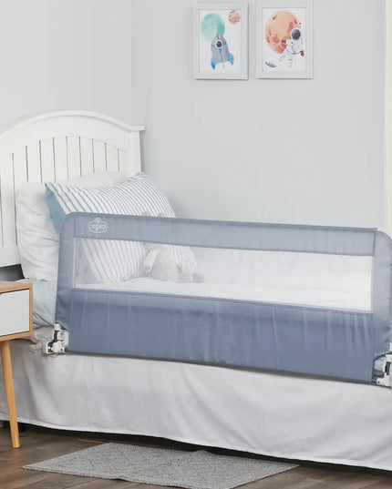Children's bed with a gray safety rail in a room with a white wall and framed pictures.