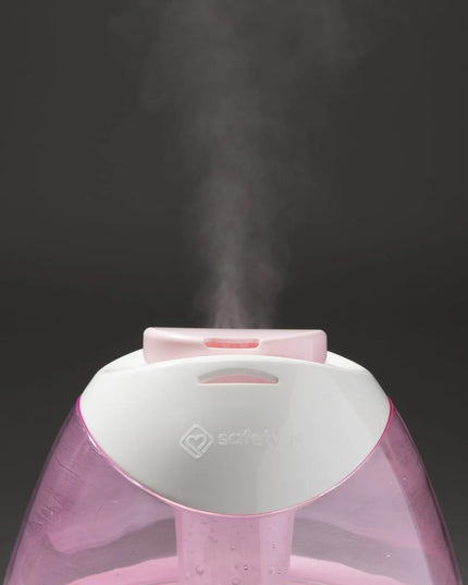 Pink humidifier emitting steam on a black background