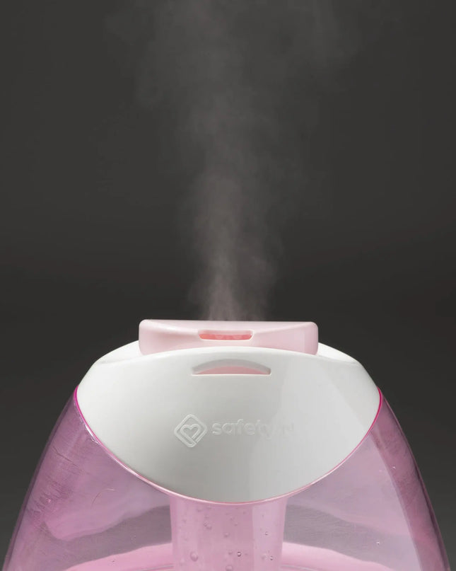 Pink humidifier emitting steam on a black background