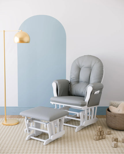Gray glider chair with ottoman in a nursery setting with a lamp and basket.