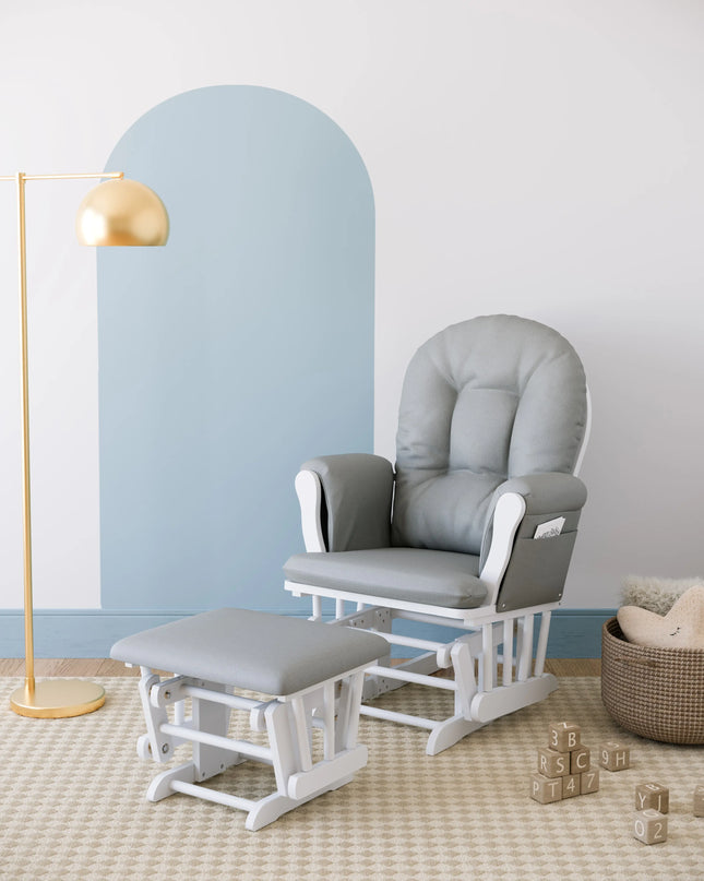 Gray glider chair with ottoman in a nursery setting with a lamp and basket.