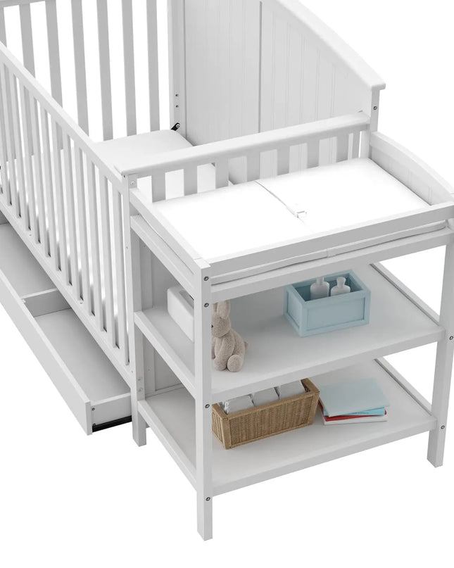 White crib with changing table and baby items on a white background