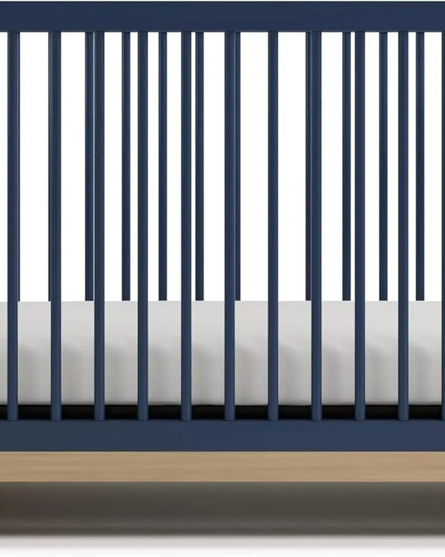 Navy crib with white mattress on a white background