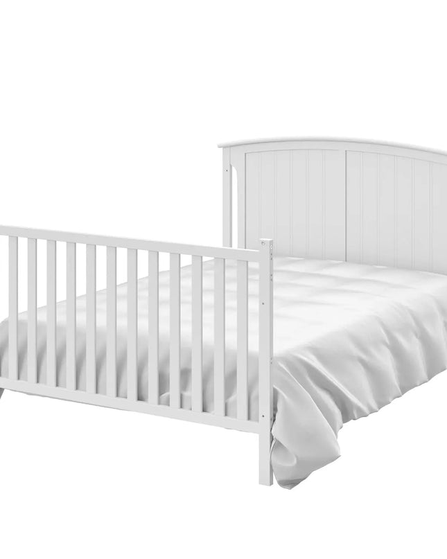 White crib with a white mattress on a white background