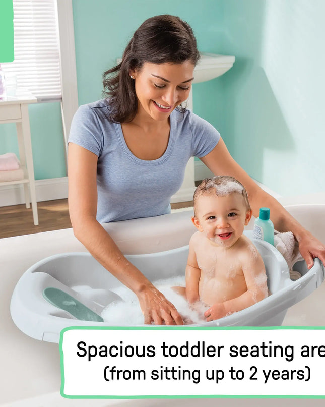 Woman and child in a bathtub with a spacious toddler seating area, surrounded by bath products.