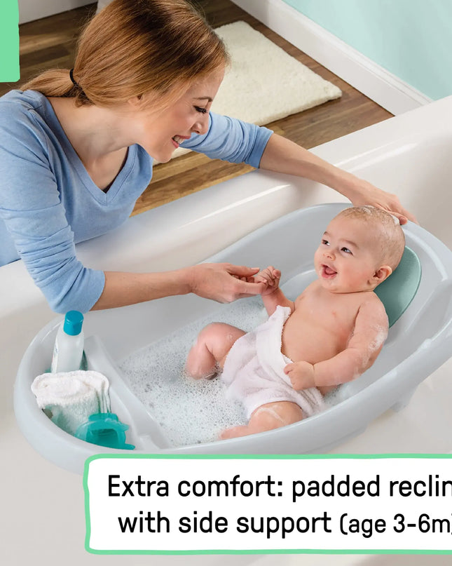 Woman bathing a baby in a white bathtub with side support, text indicating comfort features.
