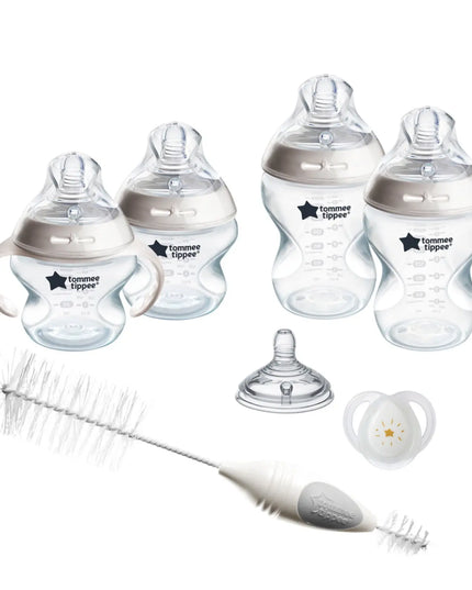 Collection of Tommee Tippee baby bottles, pacifier, and cleaning brush on a white background