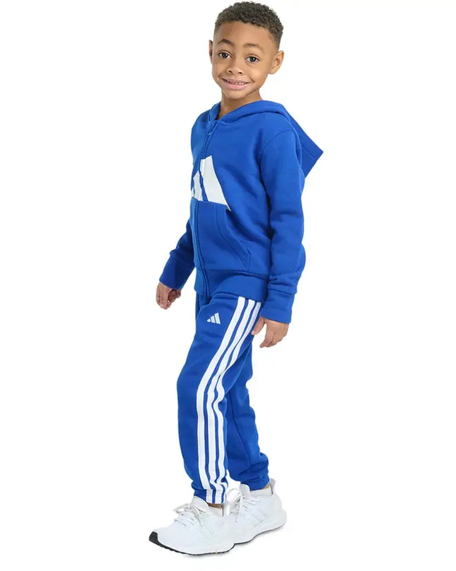 Child wearing a blue Adidas tracksuit on a white background