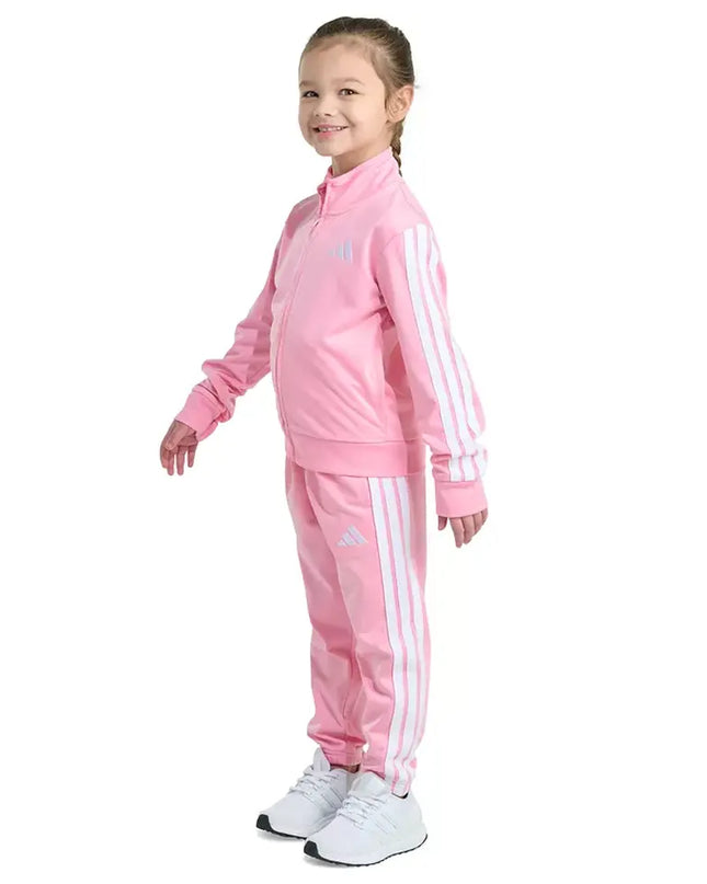 Child wearing a pink Adidas tracksuit on a white background