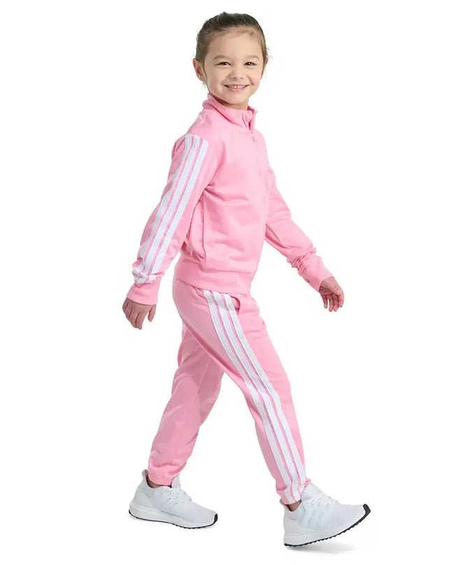 Child wearing a pink tracksuit with white stripes on a white background