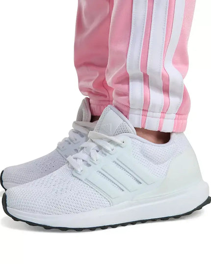 White sneakers with black soles worn with pink and white striped pants on a white background