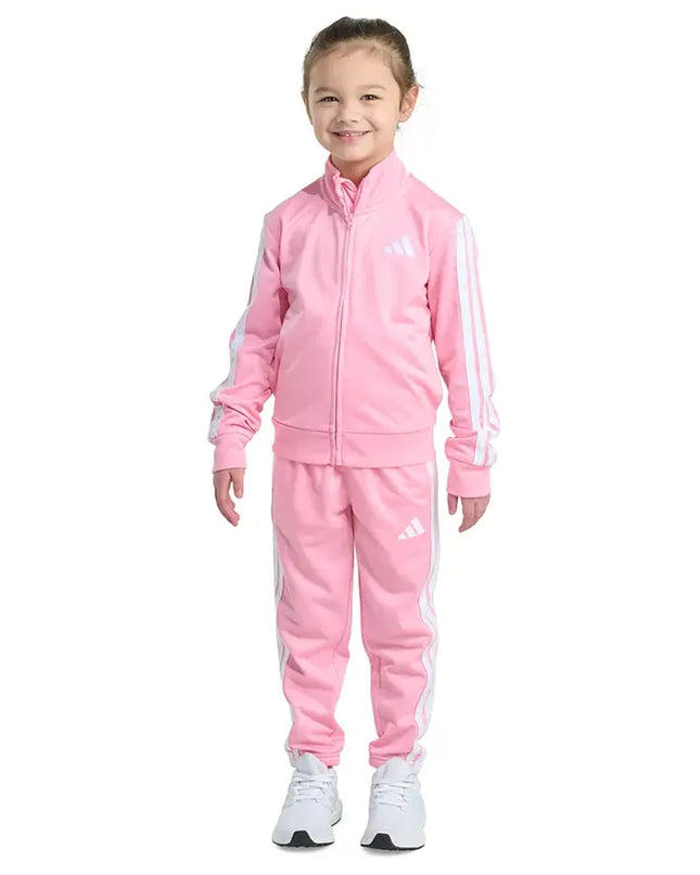 Child wearing a pink Adidas tracksuit on a white background