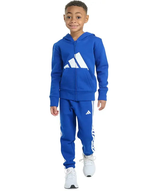 Child wearing a blue Adidas tracksuit on a white background
