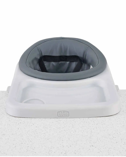 Baby seat with gray cushion and white base on a textured surface