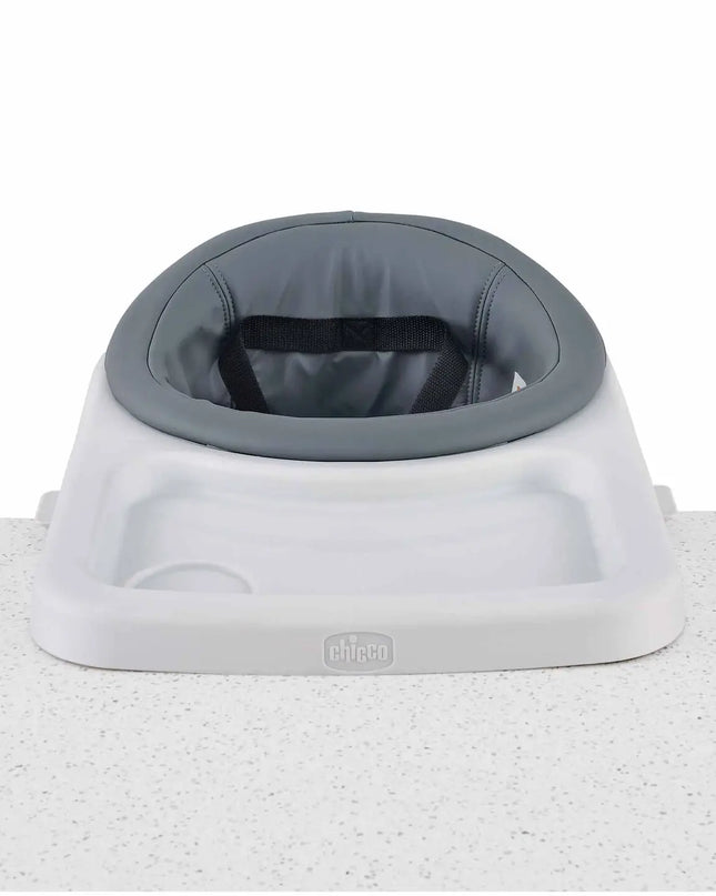 Baby seat with gray cushion and white base on a textured surface