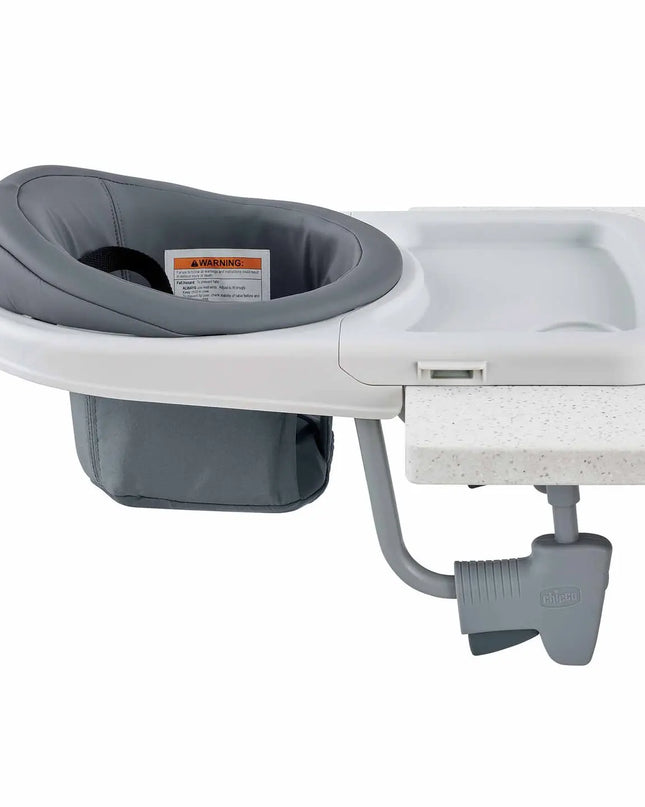 Gray baby booster seat attached to a white countertop on a white background